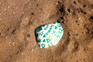 In the sand at the foot of the sign at Anne's playground are three shells with special messages for Murphy from her family.