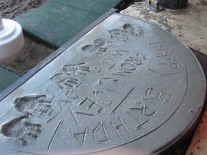 The base of a flag pole at Josephine's playground. The hand prints are those of her father, mother and two sisters.