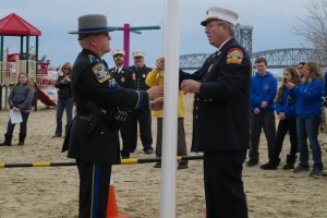 Newtown State Trooper Lonny Mo and Roxbury Volunteer Fire Department Chief Richard Colleran raise a special Newtown flag.