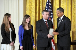 President Barack Obama presents a 2012 Citizens Medal to the family of slain Sandy Hook Elementary School teacher Anne Marie Murphy. (Photo by Jewel Samad/AFP/Getty Images)